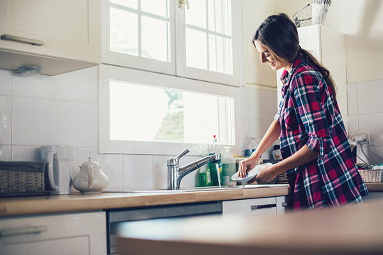 A person happily washing dishes with an unclogged drain in the San Jose and South Bay, California, area
